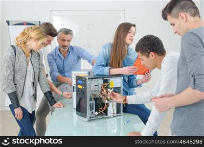 Group of students around dismantled computer