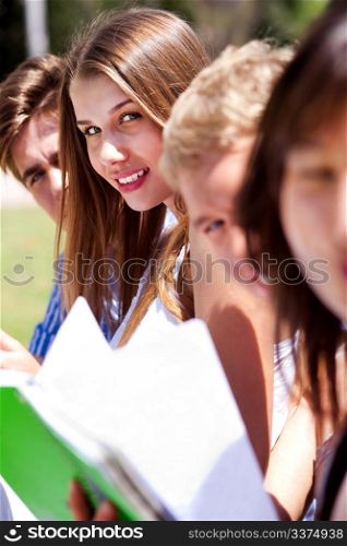 group of students reading books at the park, Female on focus
