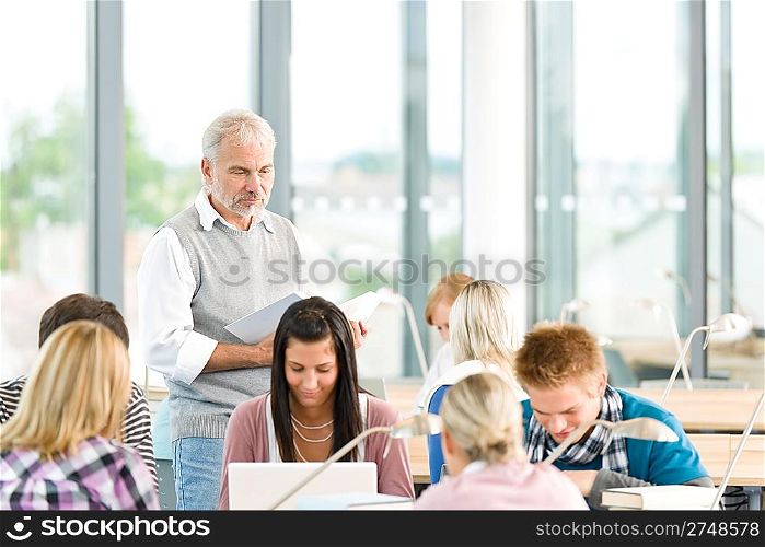 Group of students study in classroom at highschool with professor