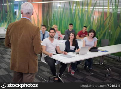 group of students study with professor in modern school classroom