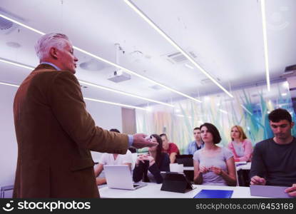 group of students study with professor in modern school classroom