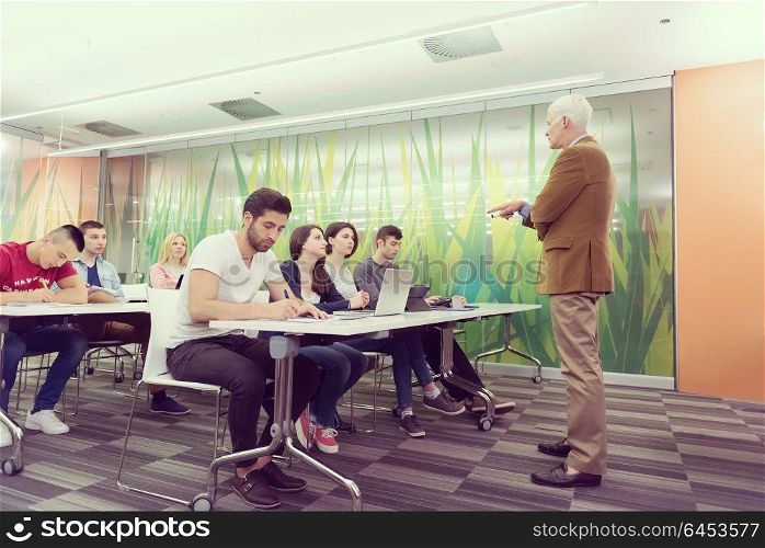 group of students study with professor in modern school classroom