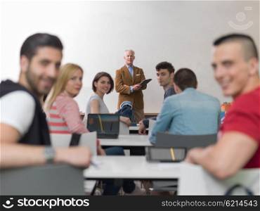 group of students study with senior professor in modern school classroom on creative class