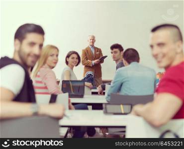 group of students study with senior professor in modern school classroom on creative class