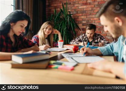 Group of students studying at the table together. Group of students studying at the table