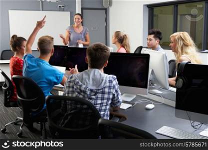 Group Of Students With Female Tutor In Computer Class