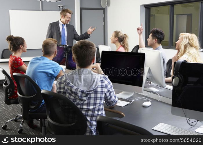 Group Of Students With Male Tutor In Computer Class