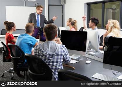 Group Of Students With Male Tutor In Computer Class