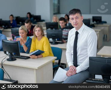 group of students with teacher in computer lab classrom learrning lessons, get help and support