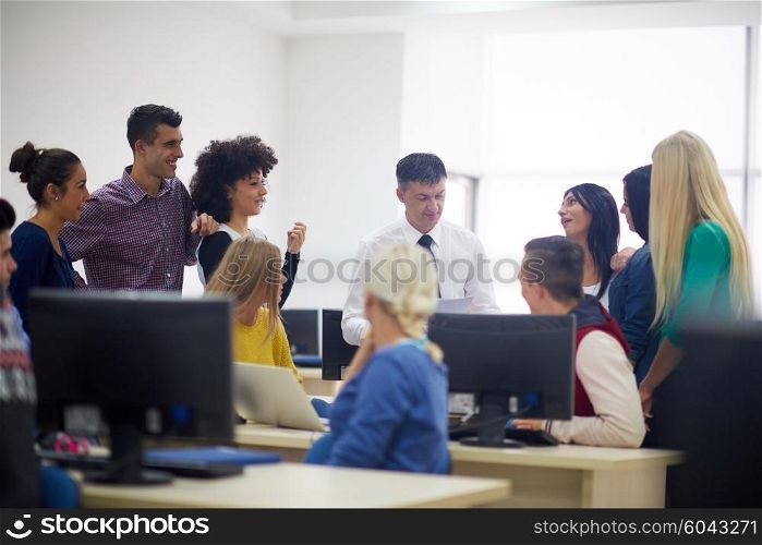 group of students with teacher in computer lab classrom learrning lessons, get help and support