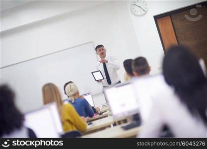 group of students with teacher in computer lab classrom learrning lessons, get help and support