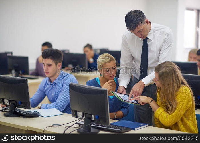 group of students with teacher in computer lab classrom learrning lessons, get help and support