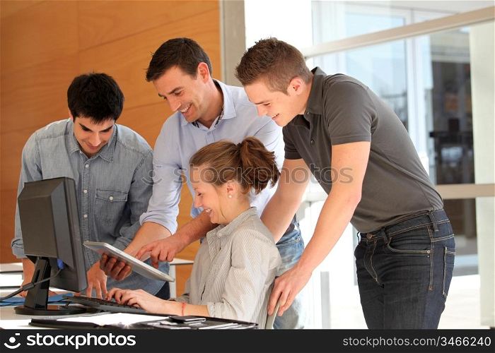 Group of students with teacher working on computer