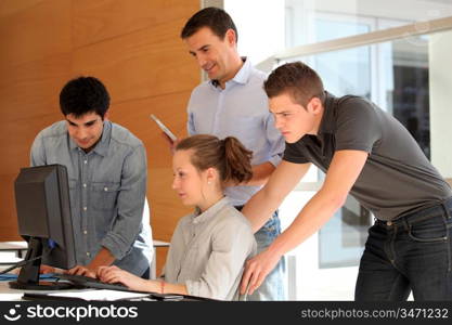 Group of students with teacher working on computer