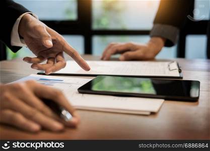 Group of successful business people discussing paperwork and using a laptop together, team work and brainstorming concept. businessman presenting something at the seminar using tablet at the office Audit concept at working.