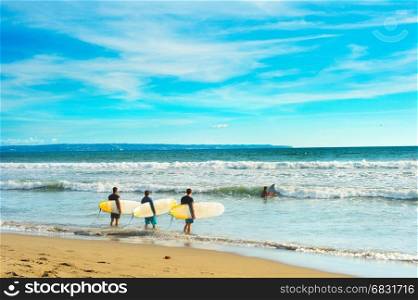 Group of surfers ready to surf on the beach. Bali island, Indonesia