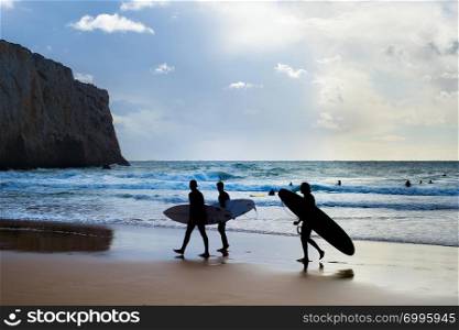 Group of surfers with surfboards on the beach. Algarve, Portugal