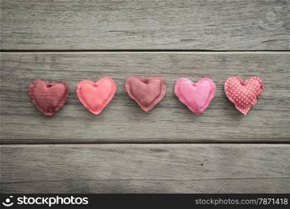 Group of sweet pink tone hearts handmade crafts from silk cloth place on wood background with vignette, , love and valentine&rsquo;s day symbol