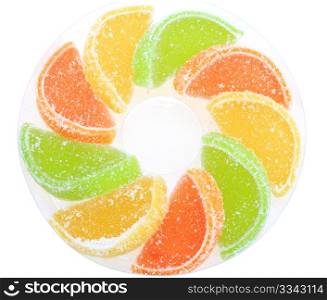 Group of sweets as citrus fruits on white plate. Isolated on white background. Close-up. Studio photography.