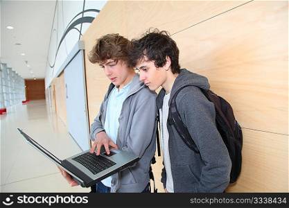 Group of teenage boys at school with laptop computer