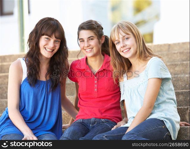 Group Of Teenage Female Friends Sitting On College Steps Outside