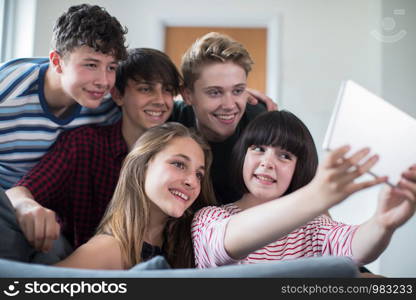 Group Of Teenage Friends Posing For Selfie On Digital Tablet