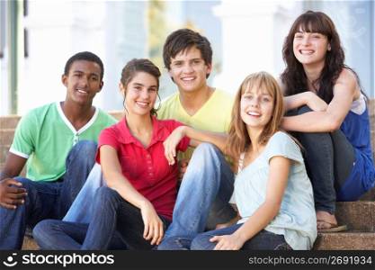 Group Of Teenage Friends Sitting On College Steps Outside