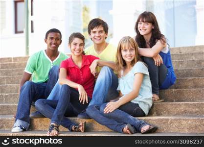 Group Of Teenage Friends Sitting On College Steps Outside