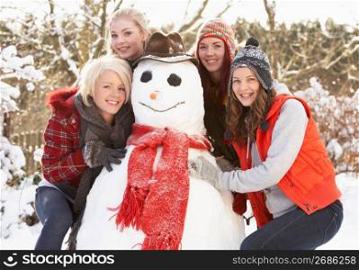 Group Of Teenage Girls Building Snowman