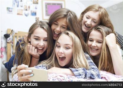 Group Of Teenage Girls Taking Selfie On Mobile Phone