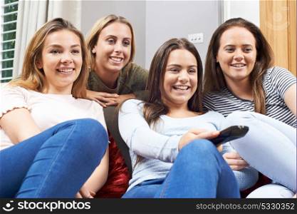 Group Of Teenage Girls Watching TV At Home Together