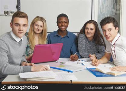 Group Of Teenage Pupils Working Together In Classroom