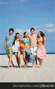 Group of teenagers (16-17) walking on beach portrait