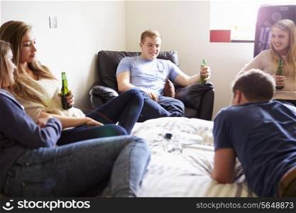 Group Of Teenagers Drinking Alcohol In Bedroom