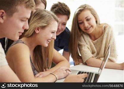 Group Of Teenagers Gathered Around Laptop Together