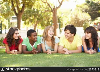 Group Of Teenagers Lying On Stomachs In Park