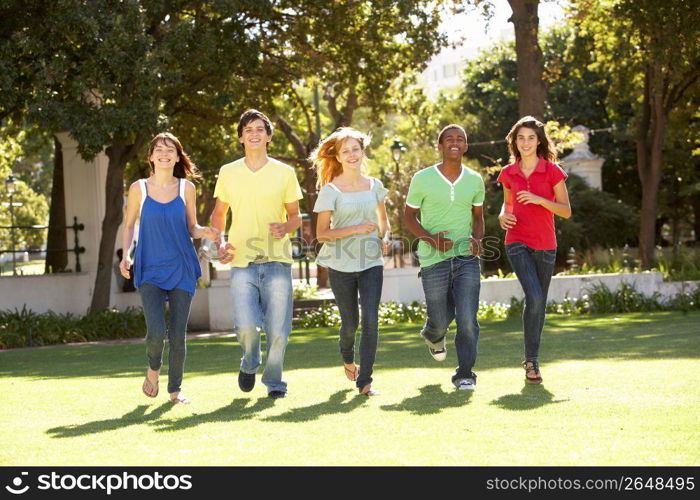 Group Of Teenagers Running Through Park