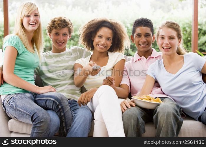 Group Of Teenagers Sitting On A Couch Eating Pizza