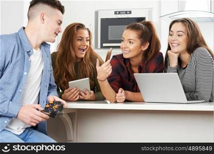 Group Of Teenagers Using Digital Technology At Home