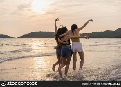Group of three Asian young women running on beach, friends happy relax having fun playing on beach near sea when sunset in evening. Lifestyle friends travel holiday vacation on beach summer concept.
