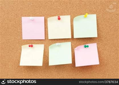 Group of thumbtack and note paper on corkboard