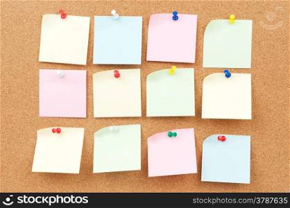 Group of thumbtack and note paper on corkboard