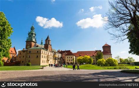 Group of tourists walking in Wawel castle, Krakow, Poland. European town with ancient architecture buildings, famous place for travel. Group of tourists in Wawel castle, Krakow, Poland