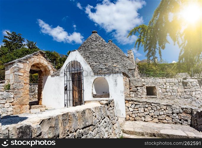 Group of Trulli with symbols, traditional old houses and old stone wall in Puglia, Italy