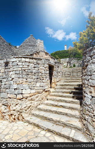 Group of Trulli with symbols, traditional old houses and old stone wall in Puglia, Italy