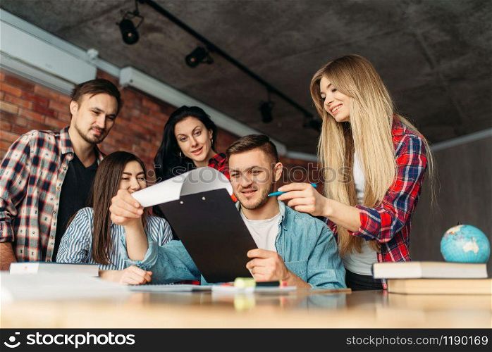 Group of university students looking on laptop together. People with computer search information in internet, teamwork, joint project