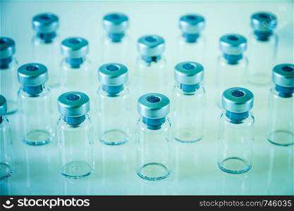 Group of vaccine glass bottles on blue background. Vaccine glass bottles on blue background
