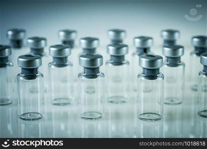 Group of vaccine glass bottles on grey background. Vaccine glass bottles on grey background