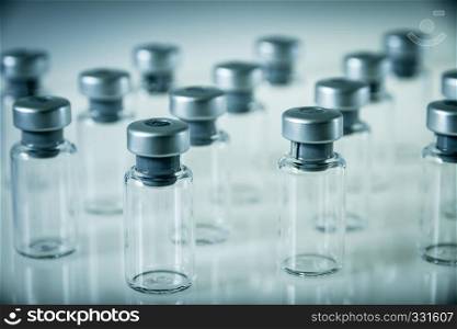 Group of vaccine glass bottles on grey background. Vaccine glass bottles on grey background