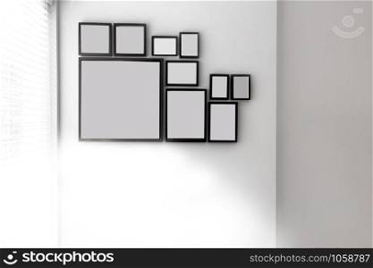 Group of various blank black picture frames on grey wall near a window with light, space for text closeup. Group of various blank black picture frames on grey wall near a window with light, space for text